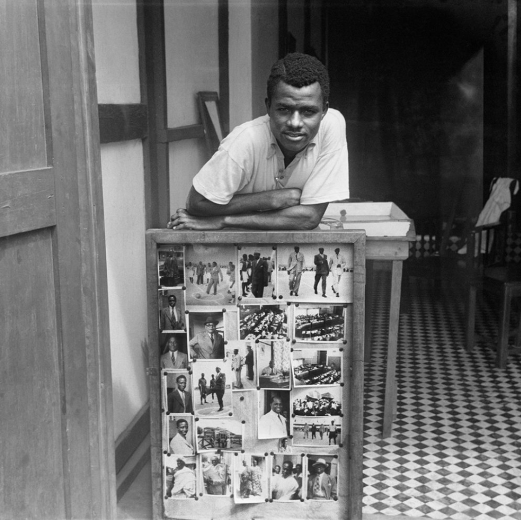 Portrait of James Barnor in front of some of his photographs, Accra, 1957, Courtesy Autograph